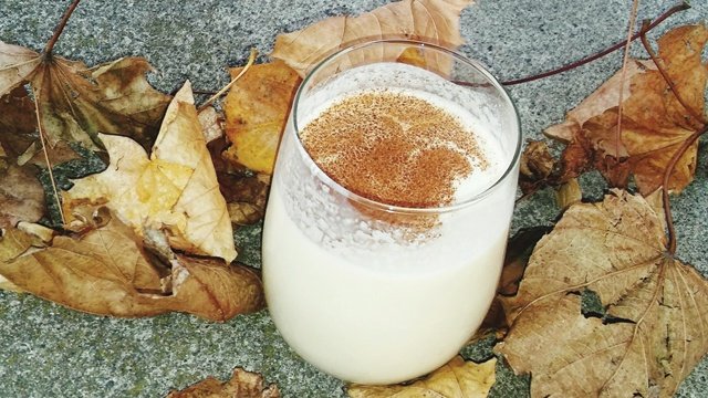 White Russian cocktail surrounded by fall leaves