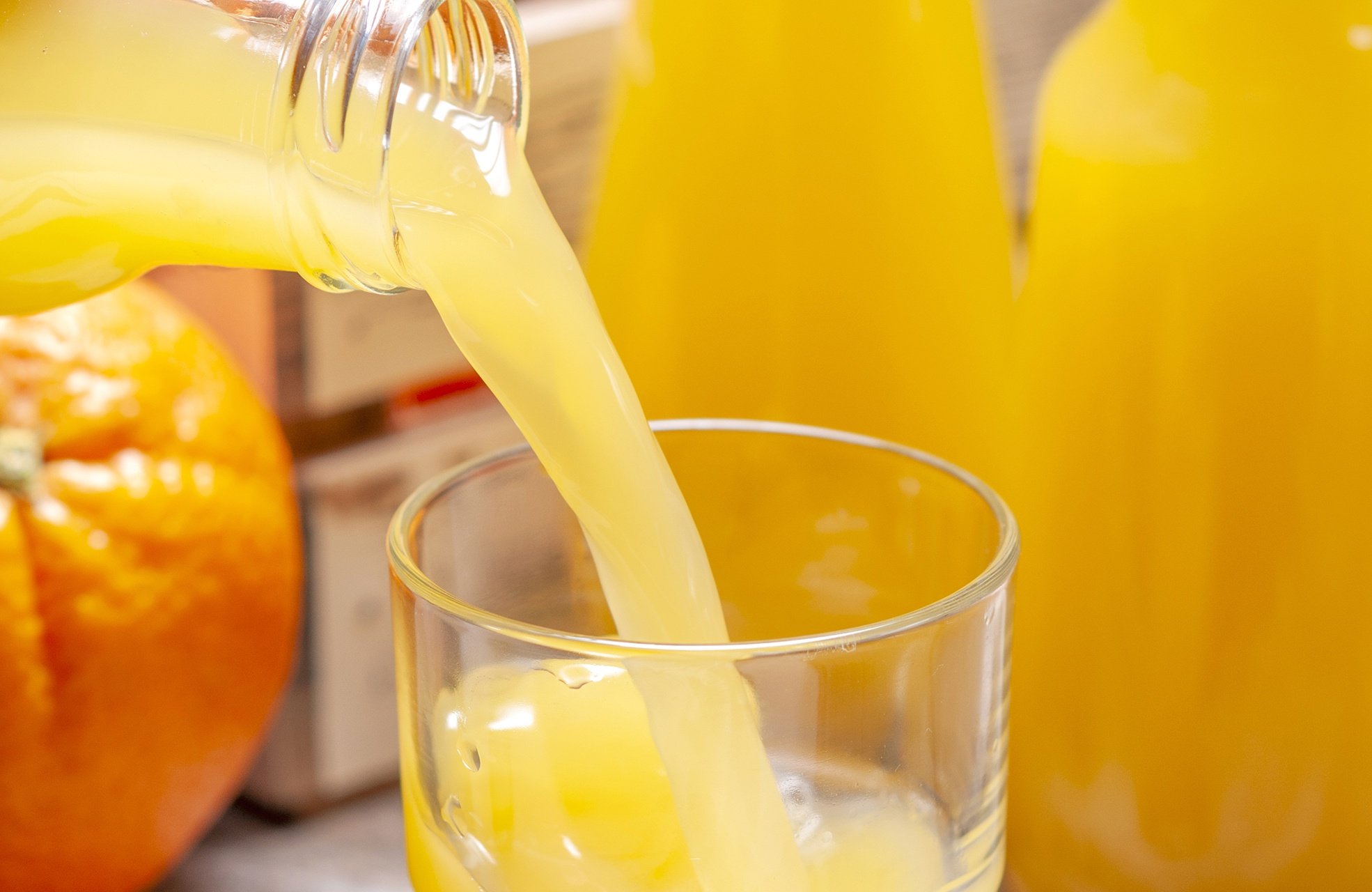 pouring orange juice into glasses