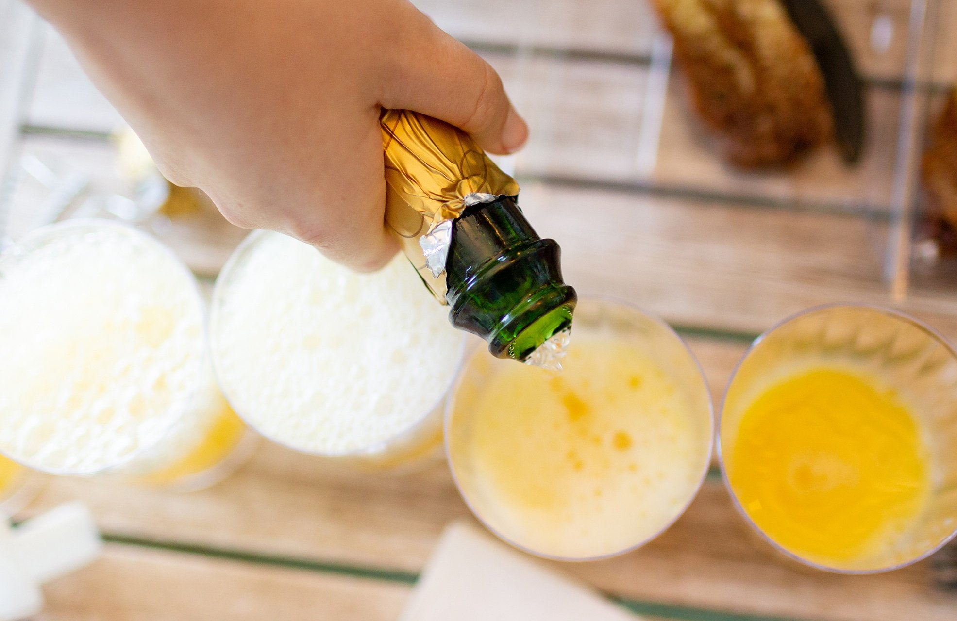 pouring sparkling wine into flutes with orange juice