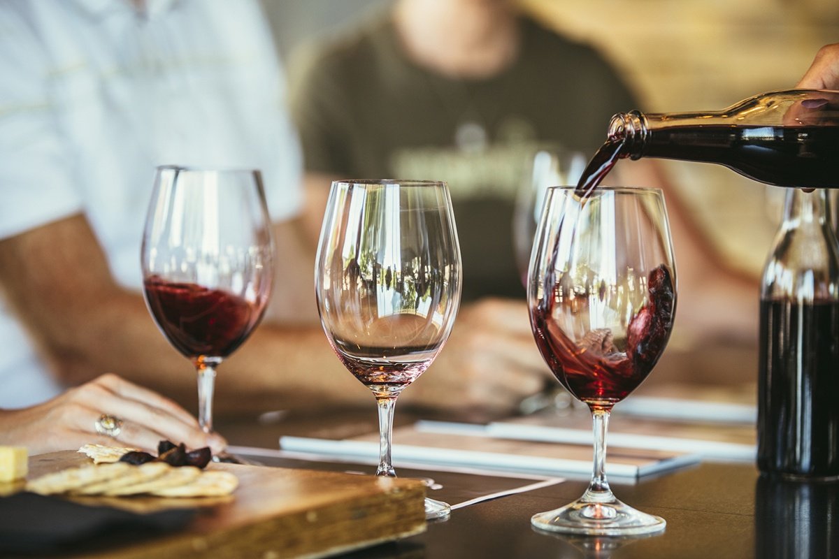 Red wine pouring into a glass at a wine tasting