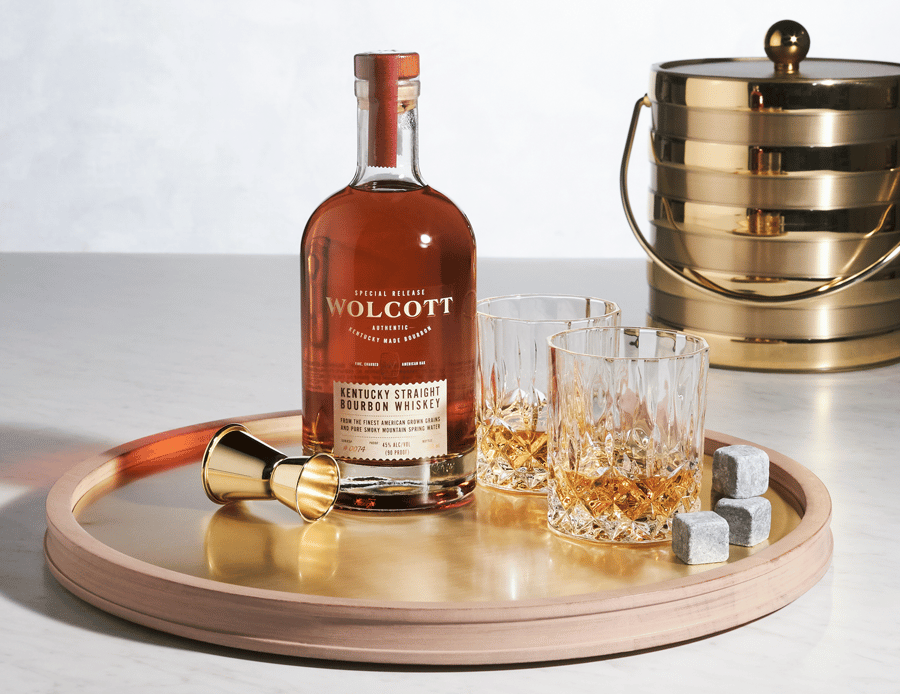 A bottle of Wolcott Bourbon poured on the rocks and ready to be enjoyed